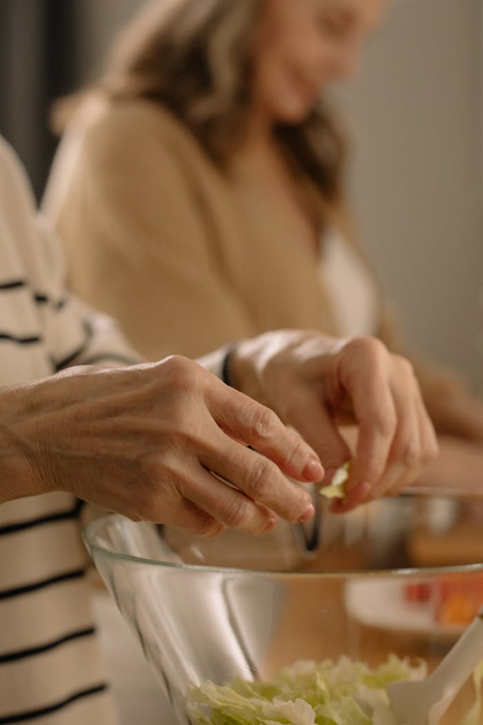 Close-up of hands making a salad. Perfect for healthy lifestyle and cooking themes.